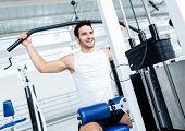 picture of fitness  - Fit man exercising at the gym on a machine - JPG 