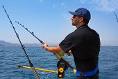 foto of pressure  - blue sea fisherman in trolling boat in action with downrigger and rod - JPG 