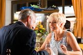 stock photo of restaurant  - Senior couple fine dining food at table in hotel or elegant restaurant - JPG 