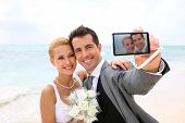 stock photo of  photo  - Bride and groom taking picture of themselves - JPG 
