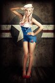 pic of beauty  - Grunge Portrait Of A Beautiful American Retro Female Cadet Dressed In Navy Uniform While Saluting In A Military Pin Up Girl Concept On Army Star Background - JPG 