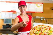 stock photo of order  - Woman holding a whole pizza in hand and asking you to ordering a pizza - JPG 