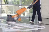 image of floors  - a worker is cleaning the floor with equipment - JPG 