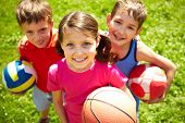 stock photo of children  - Portrait of three little children with balls looking at camera and smiling - JPG 