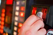 picture of insert  - Gambler inserts american dollar into slot machine - JPG 