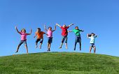 pic of group  - Group of  kids jumping on grass hill with blue sky - JPG 