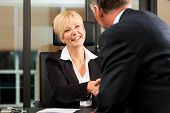 pic of handshake  - Mature female lawyer or notary with client in her office  - JPG 