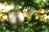picture of holidays  - Decorative gold bauble in a Christmas tree in front of a glitter background - JPG 