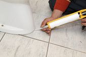 pic of silicon  - Plumber fixing toilet in a washroom with silicone cartridge - JPG 