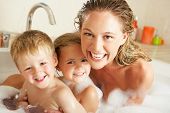 stock photo of thirties  - Mother With Children Relaxing In Bubble Filled Bath - JPG 