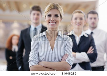 Picture or Photo of Business woman standing with her staff in background at modern bright office conference room