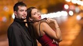 stock photo of teamwork  - Beautiful Woman Holding Businessman Tie at a city by night - JPG 