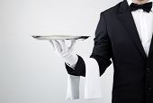 image of business concept  - Waiter holding empty silver tray over gray background - JPG 