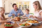 picture of family  - Happy family having roast chicken dinner at table - JPG 