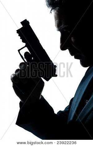 Picture or Photo of One caucasian spy criminal policeman detective man holding gun portrait silhouette in studio isolated white background