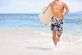 foto of fitness  - Beach fun surfer man running with bodyboard - JPG 