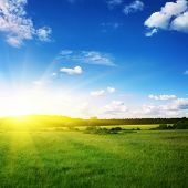 stock photo of sunset  - Beautiful sunset and green field - JPG 