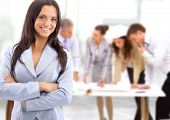 stock photo of team  - Portrait of a charismatic woman at a meeting while her team working in the background - JPG 
