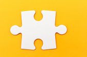 stock photo of puzzle  - Single white paper jigsaw puzzle piece on yellow background - JPG 