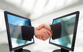 foto of handshake  - Businessmen shake hands from two lcd monitors - JPG 