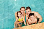 picture of family  - Photo of happy family in swimming pool smiling at camera - JPG 