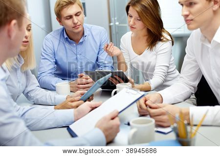 Picture or Photo of Image of several employees discussing new ideas in groups at meeting
